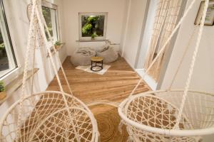 a room with three hanging chairs and a room with windows at THEFIVE60 Apartments in Braunlage