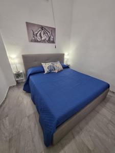 a bedroom with a bed with a blue comforter at Giomasue' in Porticello