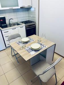 a kitchen with a table with plates and glasses on it at Rajs Apartment in Tirana +19 photos