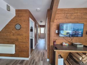 een woonkamer met houten wanden en een tv aan de muur bij Chalets du Domaine - RUSTIQUE in Notre-Dame-Des-Bois