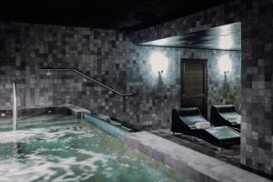 a swimming pool with two chairs in the water at Grand Brizo Bel Air in Buenos Aires