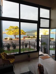 a living room with a large window looking out at the water at Loft by the sea in Amfilochia +27 photos