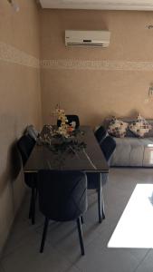 een eetkamer met een tafel, stoelen en een bank bij Appartement meublée in Kenitra