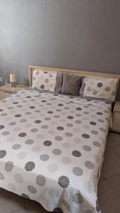 een bed met een polka dot deken erop bij Appartement meublée in Kenitra