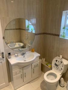 a bathroom with a sink and a toilet and a mirror at Sami in Southend-on-Sea +14 photos
