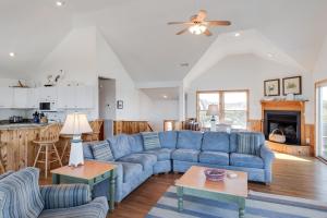 a living room with a blue couch and a kitchen at Sea-renity in Corolla