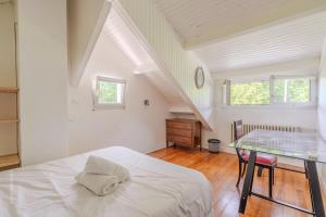 ein Schlafzimmer mit einem weißen Bett und einem Tisch in der Unterkunft Beautiful House 12 Person 20min Paris - Disney in Gournay-sur-Marne