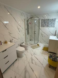 ein weißes Badezimmer mit Toilette und Dusche in der Unterkunft Casa Grande para 7 personas in Balneario Claromecó