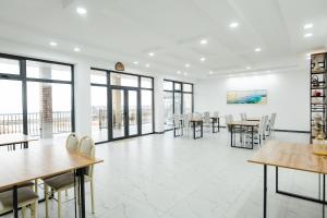 a dining room with tables and chairs and windows at Rai-Mery in Kaji-Say