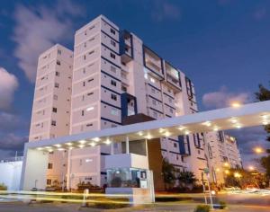 ein großes weißes Gebäude mit Lichtern davor in der Unterkunft Departamento Residencial erca de Centros Comerciales in Cancún