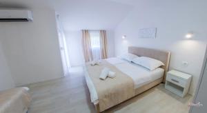 a bedroom with a bed with two towels on it at Apartments Elle in Čitluk