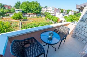 a table and chairs on a balcony with a view at Apartments Elle in Čitluk