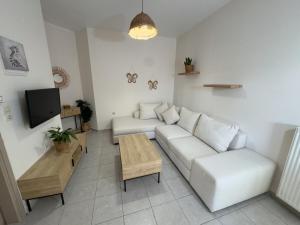 a living room with a white couch and a table at Nikolet apt 1 in Rethymno Town