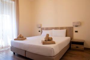 una camera da letto con un grande letto bianco con asciugamani sopra di JSK Suite a Roma