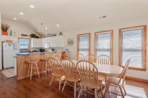Una cocina y un comedor con mesa y sillas. en Flip Flop Inn by Village Realty, en Nags Head