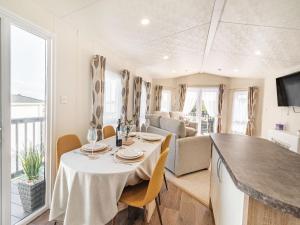 a kitchen and living room with a table and chairs at Red Wood Lodge - Uk40849 in Scarborough