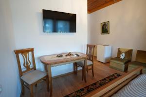a room with a table and a chair and a television at Amalia's House in Gjirokastër
