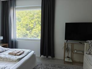 a bedroom with a bed and a large window at Kampuksen Hertta in Pori