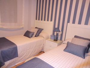 Łóżko lub łóżka w pokoju w obiekcie APARTAMENTOS DE CANELAS SUITES con AMPLIAS TERRAZAS