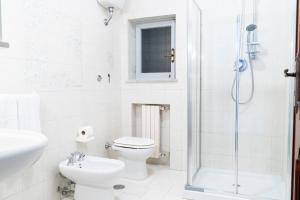 a white bathroom with a toilet and a shower at Villa Alloro in Massa Lubrense +11 photos