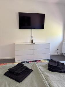 a white dresser with two black towels on top of it at Modernes Zimmer am Campus 3 mit Gemeinschaftsbad in Villingen-Schwenningen +1 photo