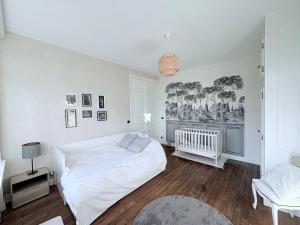 a white bedroom with a bed and a chair at Magnificent Bourgeois Residence on Wooded Estate in Charleville-Mézières