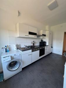 a kitchen with a washing machine and a washer at Modernes Zimmer am Campus 3 mit Gemeinschaftsbad in Villingen-Schwenningen