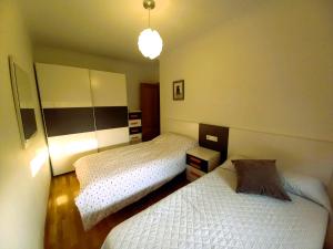 1 dormitorio con 2 camas individuales y luz en EnFOZ PLAYA DE LLAS, en Foz