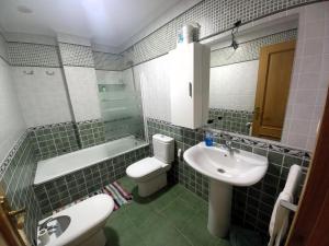 Un baño con un lavabo y un inodoro y un lavabo. en EnFOZ PLAYA DE LLAS, en Foz 24 fotos más