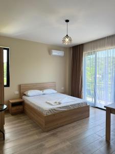ein Schlafzimmer mit einem Bett und einem großen Fenster in der Unterkunft Mirza Guesthouse in Batumi