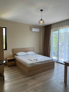 ein Schlafzimmer mit einem Bett und einem großen Fenster in der Unterkunft Mirza Guesthouse in Batumi