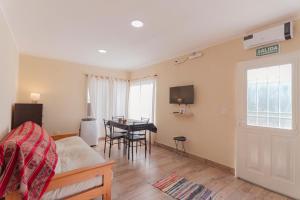a bedroom with a bed and a dining room with a table at Cabañas La Fortaleza in La Caldera