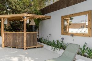 a wooden pergola and a chair on a patio at Vago Ibiza in San Antonio Bay +21 photos
