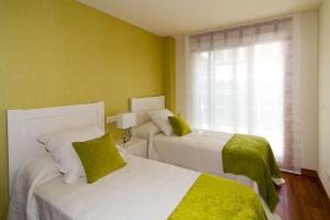 Łóżko lub łóżka w pokoju w obiekcie APARTAMENTOS DE CANELAS SUITES con AMPLIAS TERRAZAS