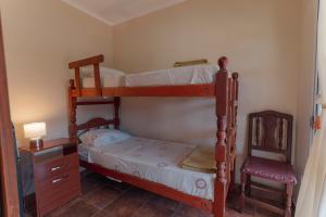 a bedroom with two bunk beds and a chair at Cabañas La Fortaleza in La Caldera +23 photos