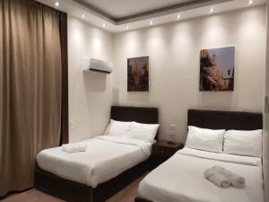 two beds in a hotel room with white sheets at Talaat Harb Hotel in Cairo +14 photos