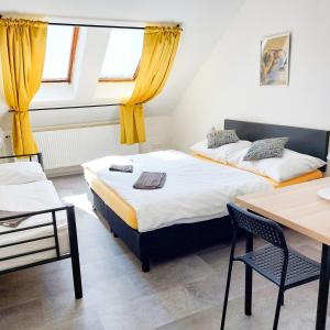 two beds in a room with a table and chairs at Beautiful attic room R3 in Prague