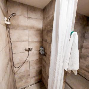a shower in a bathroom with a shower curtain at Beautiful attic room R3 in Prague +9 photos