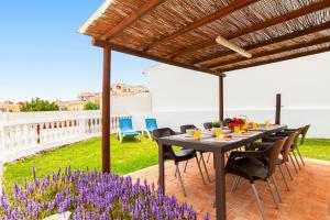 a table and chairs on a patio with purple flowers at Villa Casablanca by Algarve Vacation in Portimão