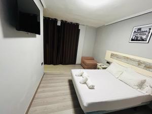 ein kleines Zimmer mit einem Bett und einem Flachbildfernseher in der Unterkunft Chalet encanto in Chiva