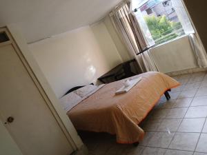 a bedroom with a bed in a room with a window at Hostal Caxamarcorco in Cajamarca