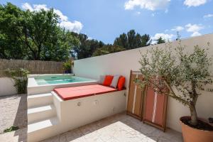 a patio with a bench next to a swimming pool at Villa Augustine - Maison classée 5 étoiles avec piscine à Aix en Provence in Aix-en-Provence