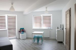 a white room with a table and three windows at Pensjonat Lazytown in Pogorzelica