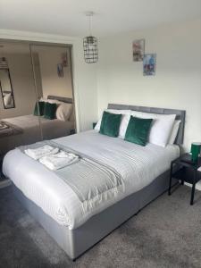 a bedroom with a large bed with green and white pillows at NEW - 3 Bedroom House in East Kilbride in East Kilbride +9 photos