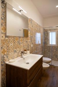 ein Badezimmer mit Waschbecken, Toilette und Spiegel in der Unterkunft La casetta di Nina in Castellana Grotte