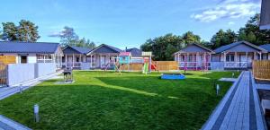 a yard with a playground with houses in the background at Pastelowe Borne SRC in Borne Sulinowo