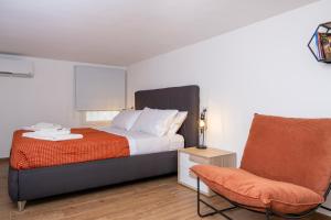 ein Schlafzimmer mit einem Bett und einem Stuhl in der Unterkunft La casetta di Nina in Castellana Grotte