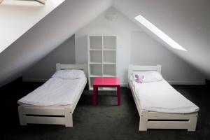 two beds in a room with a pink table at Pensjonat Lazytown in Pogorzelica