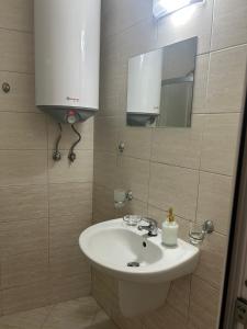 un bagno con lavandino e specchio di Судио Диксан a Pomorie Altre 12 foto