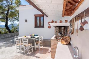 an outdoor kitchen with a table and a fireplace at Bleu & Vert in Skopelos Town